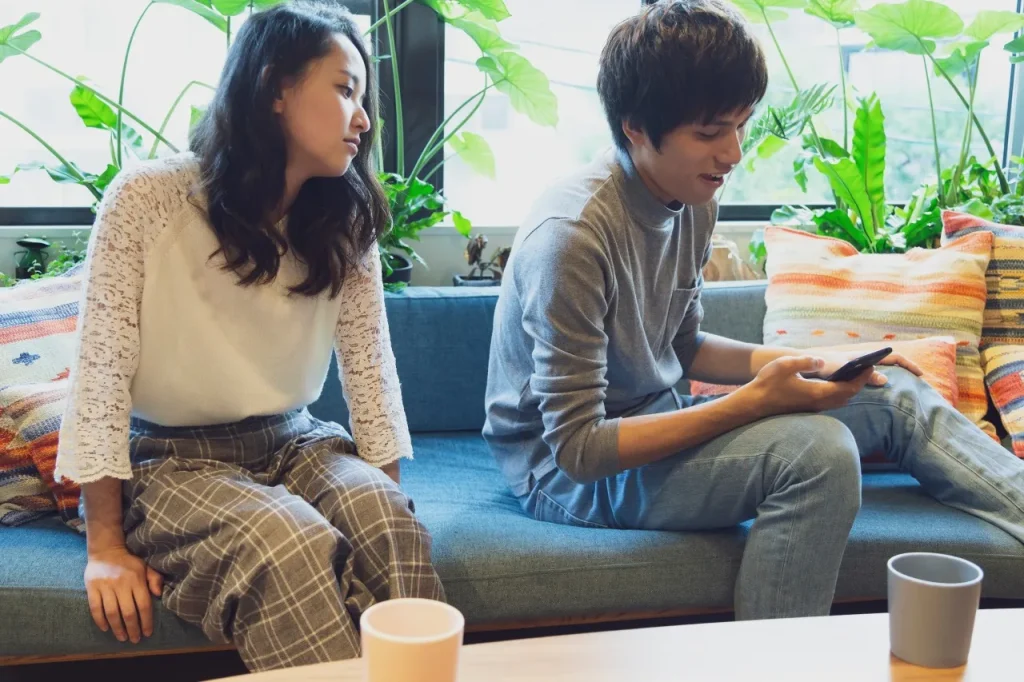 携帯を見る男性と退屈な女性